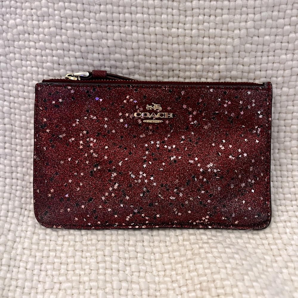 Coach Glitter Stars in Burgundy Wristlet with Gold and Black Stars
